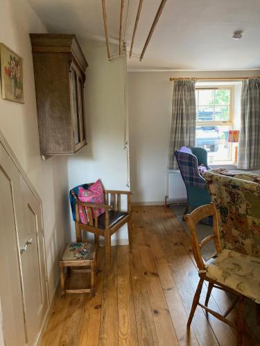 a living room with a couch and chairs and a window at Quirky Highland Cottage with Stunning Views in Wester Fearn