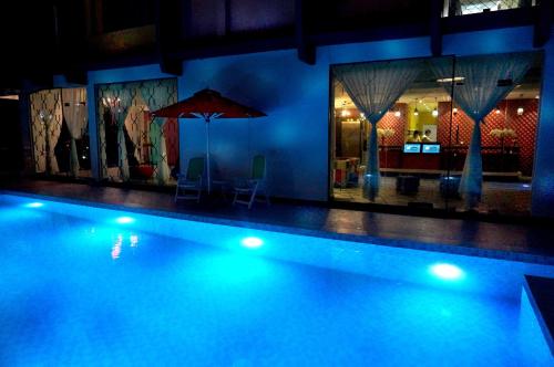 a swimming pool at night with blue lights at Langit Langi Hotel @ Port Dickson in Port Dickson