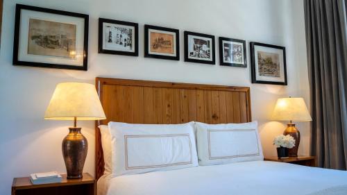 a bedroom with a bed with two lamps and pictures on the wall at Narbona Wine Lodge in Carmelo