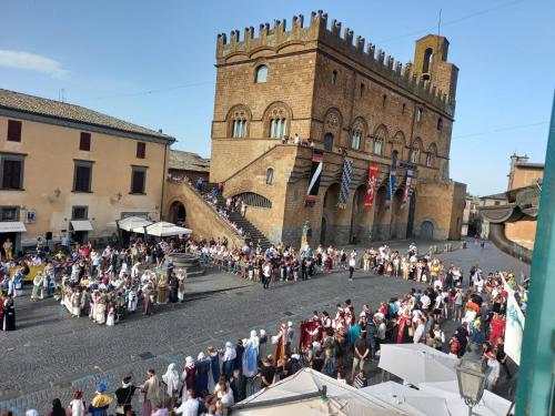 a crowd of people standing in front of a castle at Camere Urbevetus in Orvieto