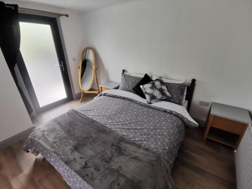 a bedroom with a bed and a large window at Orchard Cottage in Wexford