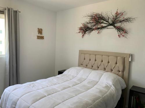 a bedroom with a bed with a flower wreath on the wall at Departamento en Acapulco Diamante in Acapulco