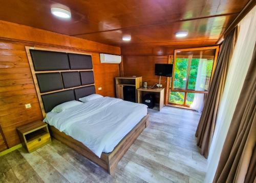 Un dormitorio con una cama grande y una ventana en Mtirala National Park hotel ORBEZA en Kobuleti