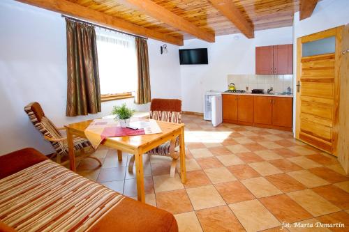 a living room with a table and a kitchen at Domki Ania in Łeba