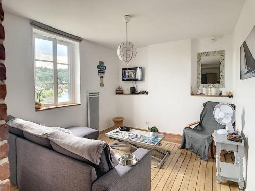 salon z kanapą i stołem w obiekcie Les Mouettes. Appart Honfleur 4 personnes vue pont de Normandie w mieście Honfleur