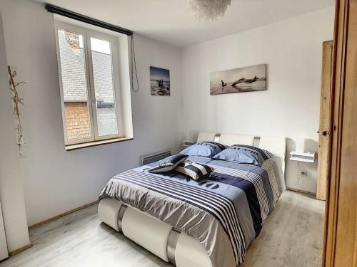 une chambre avec un grand lit avec des oreillers bleus dans l'établissement Les Mouettes. Appart Honfleur 4 personnes vue pont de Normandie, à Honfleur