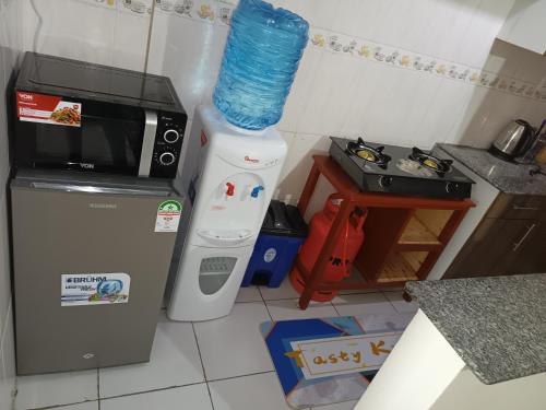 eine kleine Küche mit einer Mikrowelle und einem Kühlschrank in der Unterkunft J.J homes 1- bedroom apartment, Nairobi in Nairobi