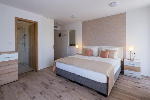 um quarto com uma cama grande e uma cabina de duche ao nível do chão em Füred Centrum Panzió em Balatonfüred