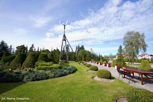 a windmill in a garden with a bench and a windmill at Domki Ania in Łeba