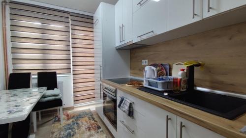 萨拉热窝SH Apartments Bistrik-Sarajevo的配有白色橱柜和台面的厨房