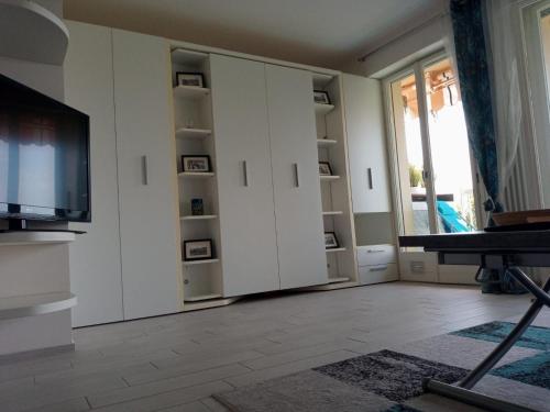 un salon avec des armoires blanches et une télévision dans l'établissement Eliana Appartment, à Menton