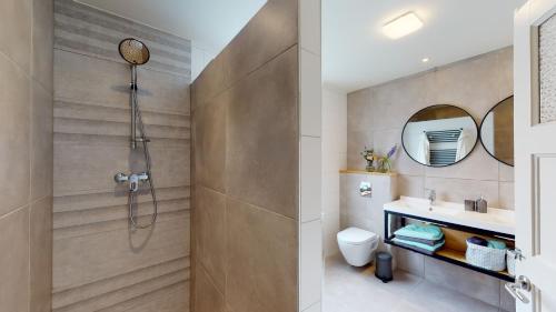 een badkamer met een douche, een toilet en een wastafel bij Bauwerd12, met hottub in de voerstreek in Voeren