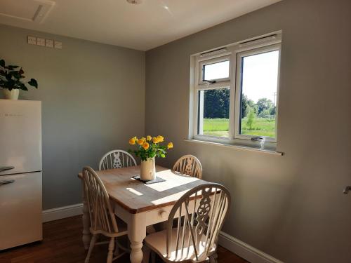 a kitchen with a table and chairs and a window at Cranfield Retreat & Glamping in Long Melford