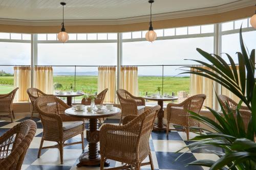 a restaurant with tables and chairs and a large window at Marine Troon in Troon