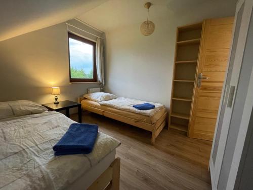 a small bedroom with two beds and a window at Domek przy Gościńcu in Golczowice