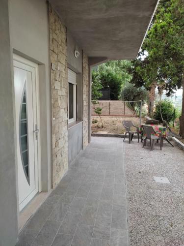 un patio con porta, tavolo e sedie di Villa Paoletti Appartamento vacanze nel cuore di Gradara a Gradara