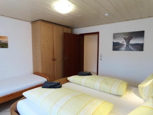 Zimmer mit 2 Betten und einem Bild an der Wand in der Unterkunft Ferienwohnung Ossiander in Uhldingen-Mühlhofen