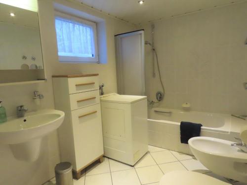 ein Badezimmer mit einer Badewanne, einem Waschbecken, einer Badewanne und einem WC in der Unterkunft Ferienwohnung Ossiander in Uhldingen-Mühlhofen