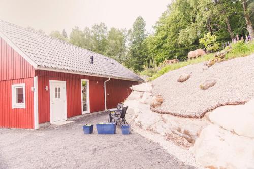 a red building with a bench in front of it at Stenlid - Med naturen och lugnet i fokus in Veddige