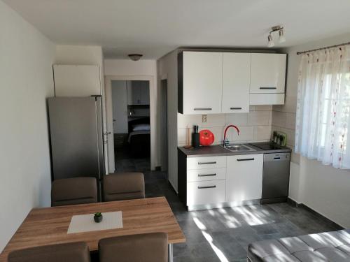 a kitchen with white cabinets and a table and a kitchen gmaxwell gmaxwell gmaxwell at Apartmani Grabovčić in Punat