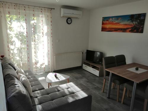a living room with a couch and a table at Apartmani Grabovčić in Punat