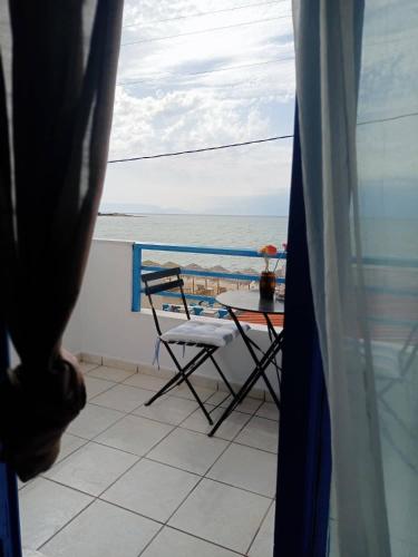 a balcony with a table and a chair and the ocean at SOLE E MARE in Elafonisos