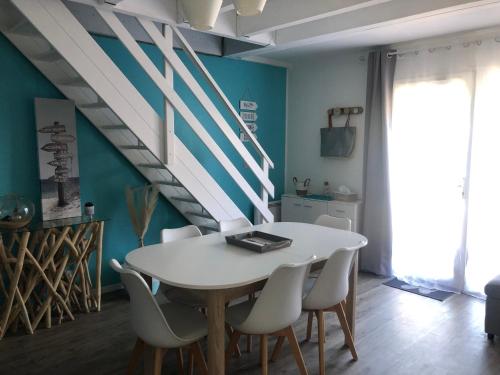 une salle à manger avec une table et des chaises blanches dans l'établissement Villa de vacances Vieux Boucau, à Soustons