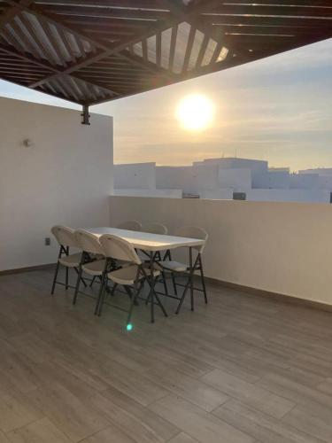 a table and chairs in a room with the sun setting at Departamento en Acapulco Diamante in Acapulco
