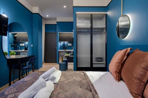Schlafzimmer mit blauen Wänden, einem Bett und einem Tisch in der Unterkunft Urban Tales in Athen