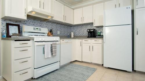 a white kitchen with white appliances and white cabinets at Molokai Island Retreat with Beautiful Ocean Views and Pool - Newly Remodeled! in Ualapue