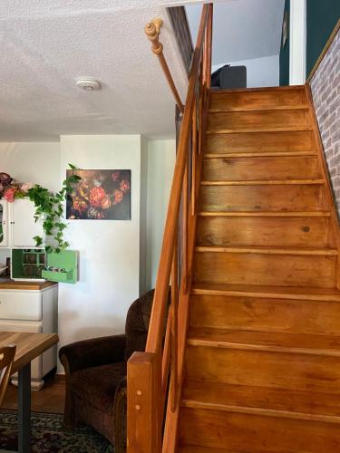 a wooden staircase in a living room with a couch at FeWo Unner'd Kastanje in Moormerland