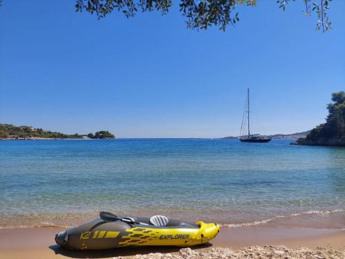 a yellow and gray raft laying on the beach at Casadelvilla private apartment PortoCheli-Kosta in Porto Heli