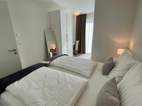 Schlafzimmer mit einem Bett mit weißer Bettwäsche und Kissen in der Unterkunft Ferienwohnung An Bord in Dangast