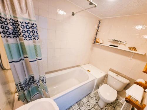 a bathroom with a tub and a toilet at Sea views, big 2 Bed Flat close to beach & harbour in Ilfracombe