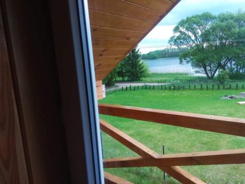 a view from the window of a house with a fence at Domki Jastrzębia Mazury in Pasym
