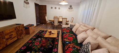 - un salon avec un canapé et une table dans l'établissement Acul în carul cu fan, à Pădurenii