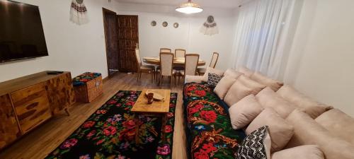 a living room with a couch and a table at Acul în carul cu fan in Pădurenii