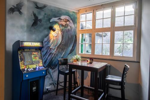 Zimmer mit einem großen Adlergemälde und einem Tisch in der Unterkunft Cwmcarn Hotel & Bunkhouse in Cwmcarn