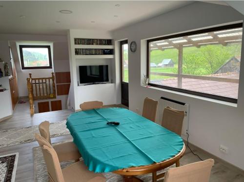 una sala da pranzo con tavolo e sedie blu di Karacsony Guest House a Lunca de Sus