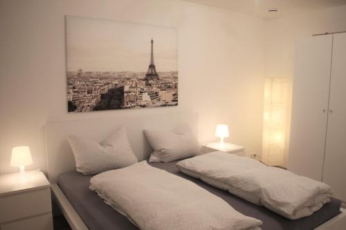 1 Schlafzimmer mit 2 Betten und einem Bild des Eiffelturms in der Unterkunft Ferienwohnung Ronja in Beckingen