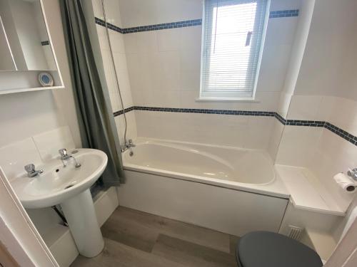 a bathroom with a sink and a tub and a toilet at Serviced Accommodation in Hull