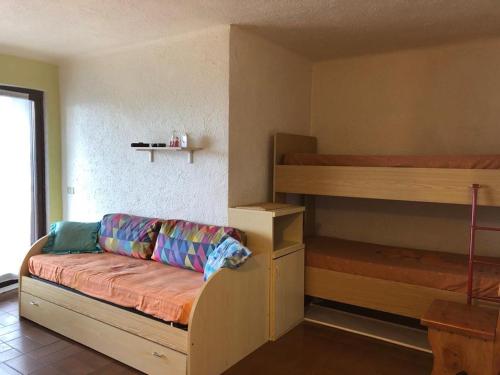 ArtogneにあるResidenza Pineta Montecampioneの二段ベッド2台とソファが備わる客室です。