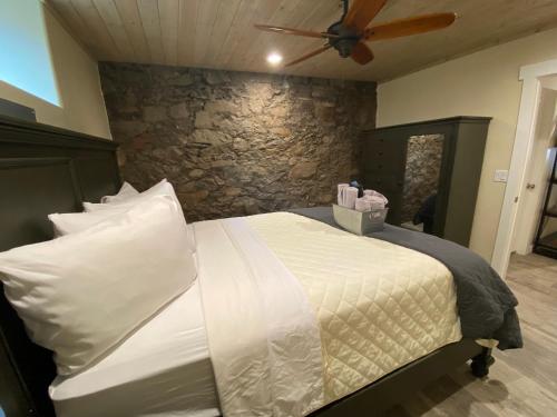 a bedroom with a bed with a stone wall at Hotel Ouray - for 12 years old and over in Ouray