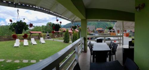 eine Terrasse mit einem Tisch und Stühlen sowie Parkblick in der Unterkunft Levi Panzio in Praid