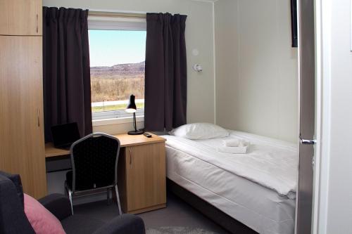a bedroom with a bed and a desk and a window at Kiruna City Room in Kiruna