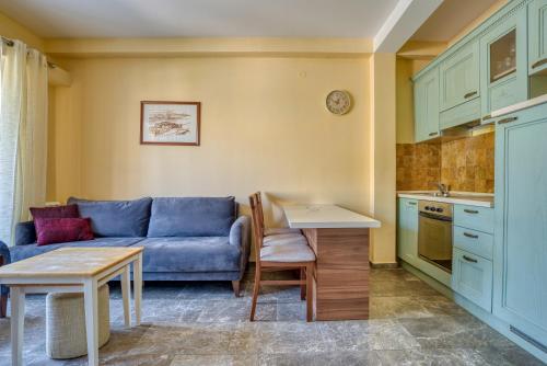 a living room with a blue couch and a kitchen at Kazanegra Exclusive Apartments in Sveti Stefan