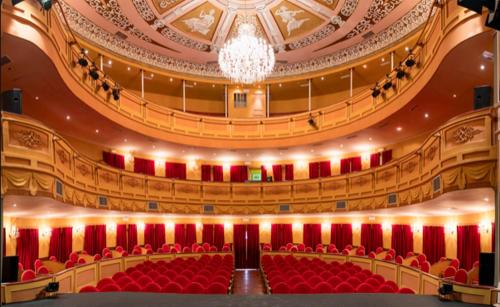 a large auditorium with red seats in a theatre at Retiro del Teatro Almagro in Almagro