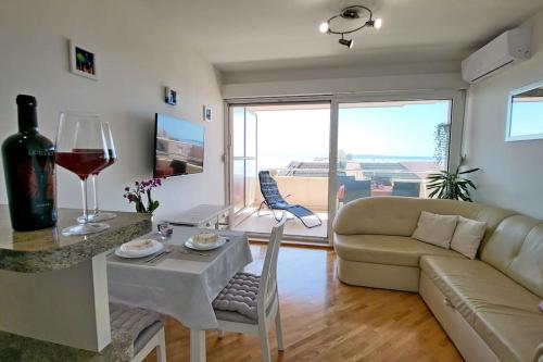uma sala de estar com um sofá e uma mesa com um copo de vinho em Apartment Summer Vibes Split em Split
