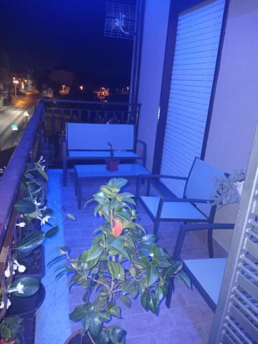 a balcony with chairs and a plant on a building at Il Paradiso di Marilyn in Milazzo
