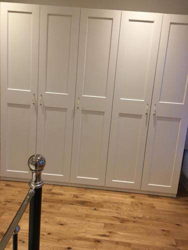 a row of white closet doors in a room at Tulse Hill Luxury Cosy Rooms in London